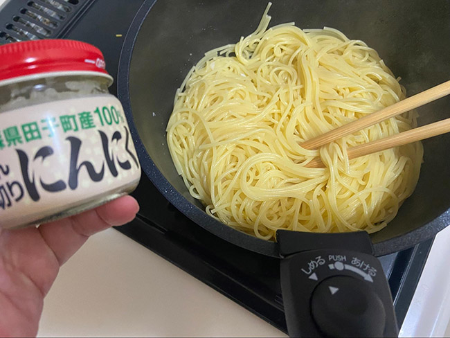 パスタが茹で上がったら、刻みニンニクとごま油で軽く炒めます