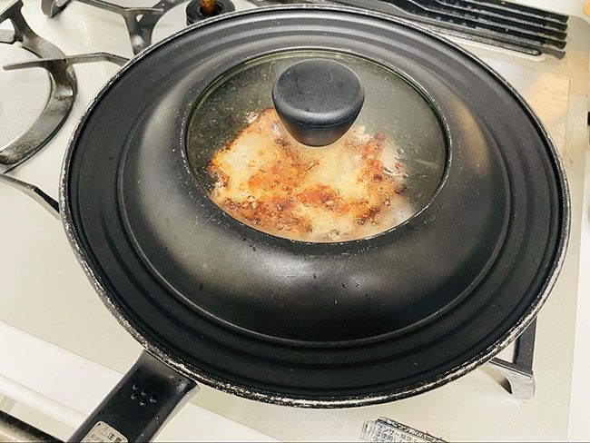 中火で熱したフライパンにオリーブオイルを入れ、鶏肉を片面4分ずつ蓋をして焼きます